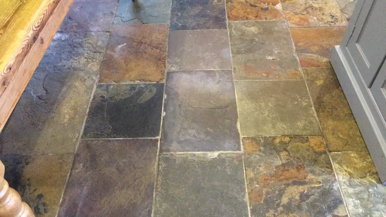 Fresh grout repair between restored slate floor tiles