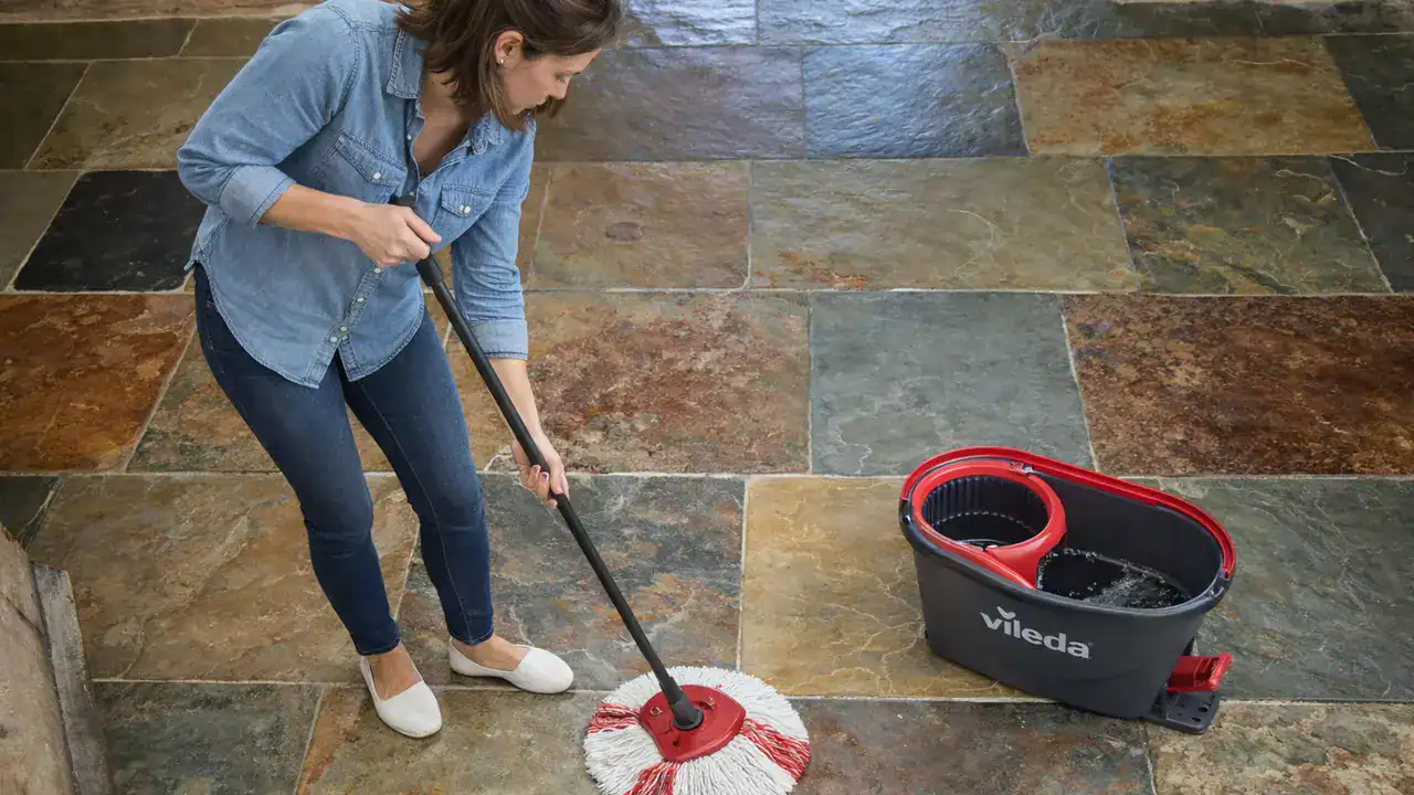 Homeowner mopping a restored slate floor with a microfibre spin mop