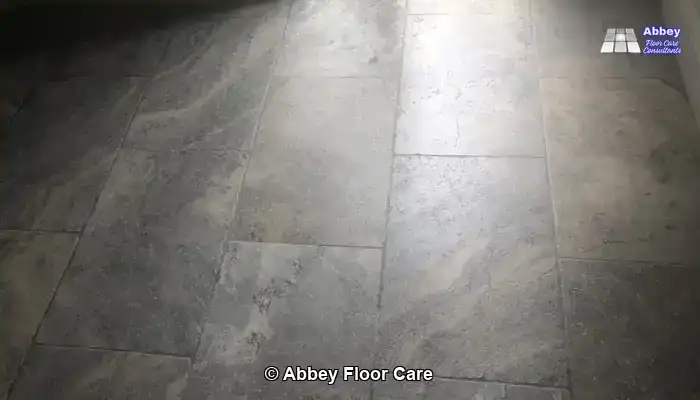 Diamond honing pad refining the surface of a tumbled travertine floor to remove light scratches