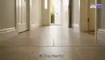 Low-angle wide shot of a clean tiled hallway in a North East England home with soft daylight reflecting gently on the floor.