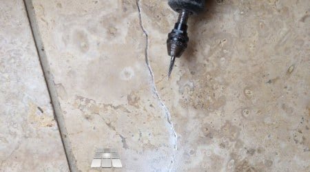 Diamond burr opeining crack in Travertine floor ready for repair