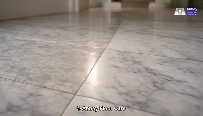 Marble tiles showing a dull, scratched area beside a newly honed area with a soft, even sheen.
