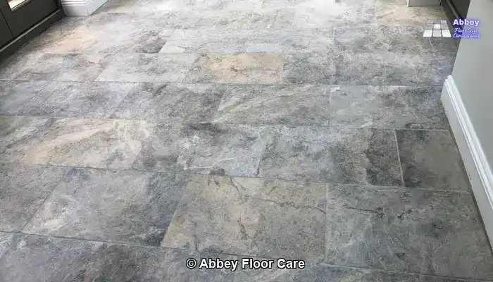 Dull, scratched tumbled travertine floor in a Hemel Hempstead kitchen with dark grout and visible pits