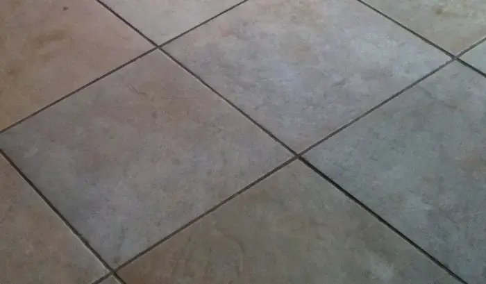 Close-up of dull ceramic tiles and darkened grout joints