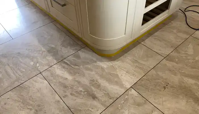 Fine grit on a marble floor surface that can cause scratching if not removed