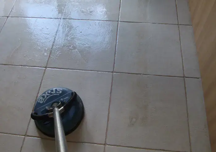 Wet vacuum extracting dirty slurry from ceramic tile floor