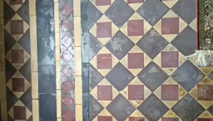 Worn Victorian Minton clay tile floor in Ovington before restoration