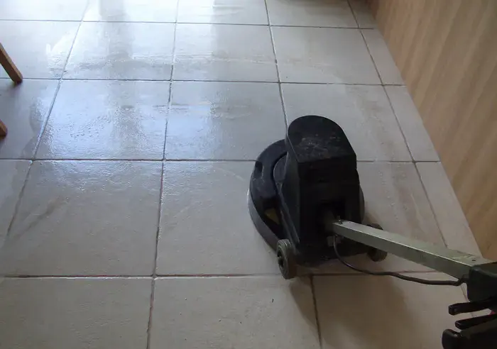 Rotary floor machine scrubbing ceramic tiles and grout lines