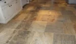 Indoor sandstone floor that still looks dull and patchy despite regular cleaning