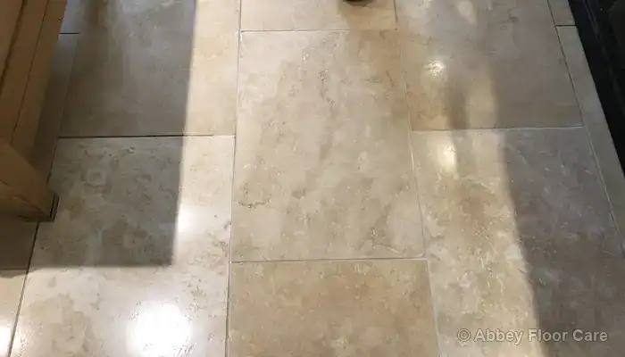 Travertine floor after repair and sealing with a consistent mid-sheen appearance.