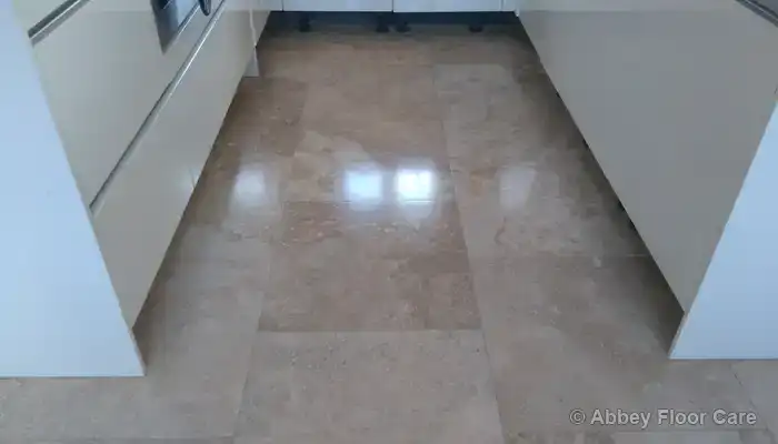 Same travertine floor after resealing, showing a more even surface finish in high-wear areas.