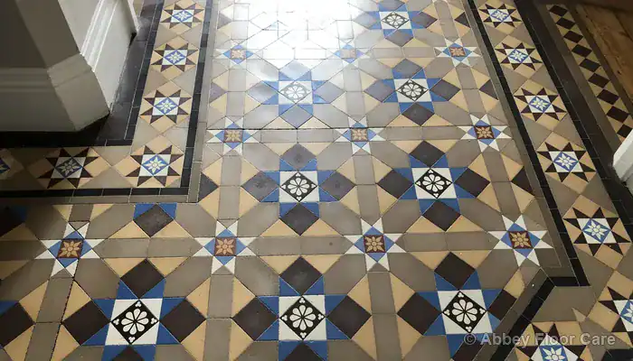 Victorian clay tile floor showing natural dishing and concave wear patterns in a hallway