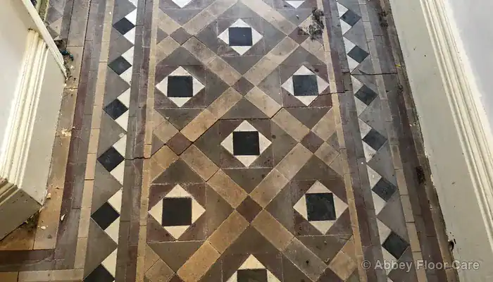 Victorian clay tile floor edge damaged by carpet gripper nails